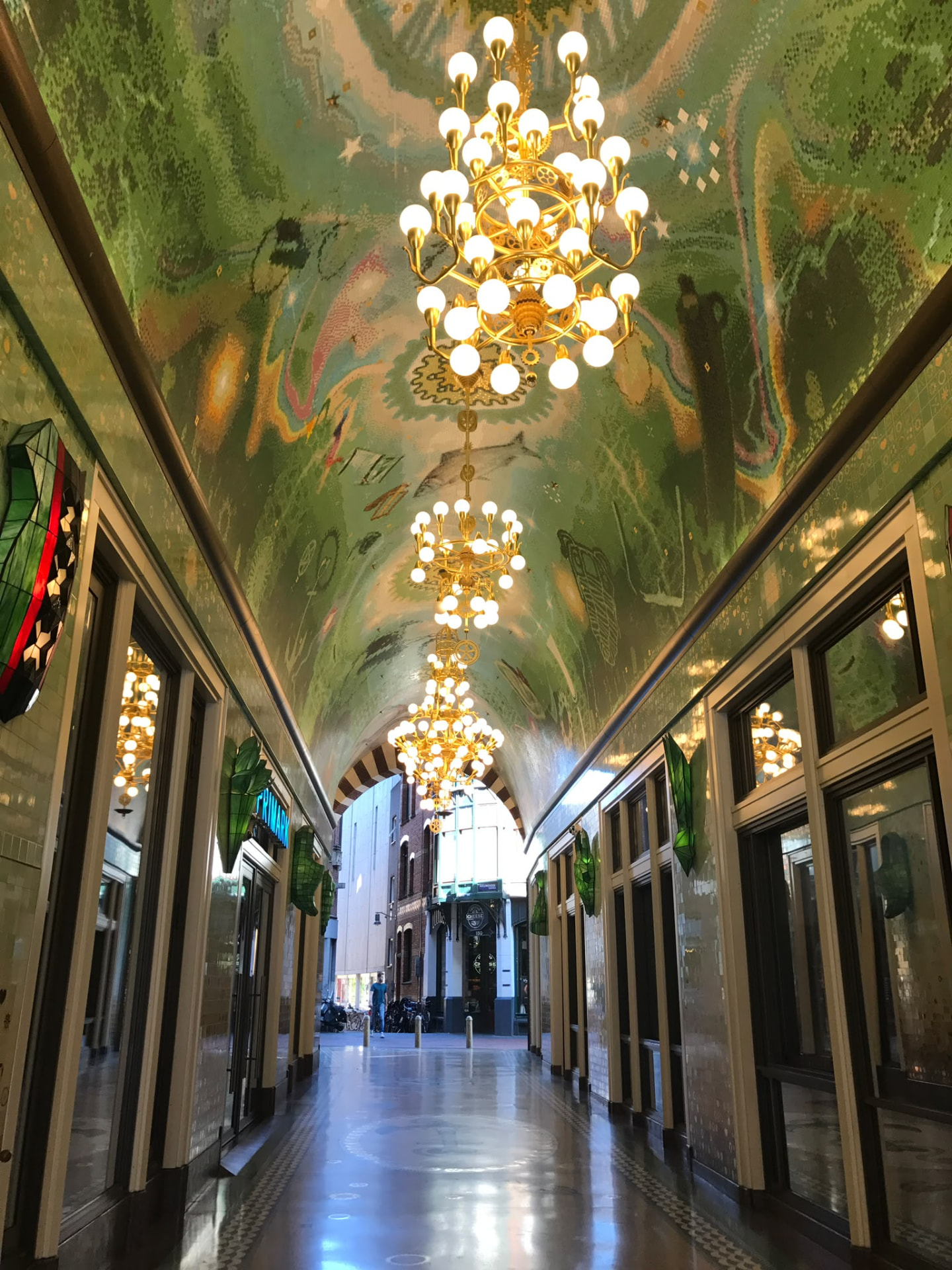 Ornate Beurspassage hallway with a mosaic fish ceiling and golden chandeliers