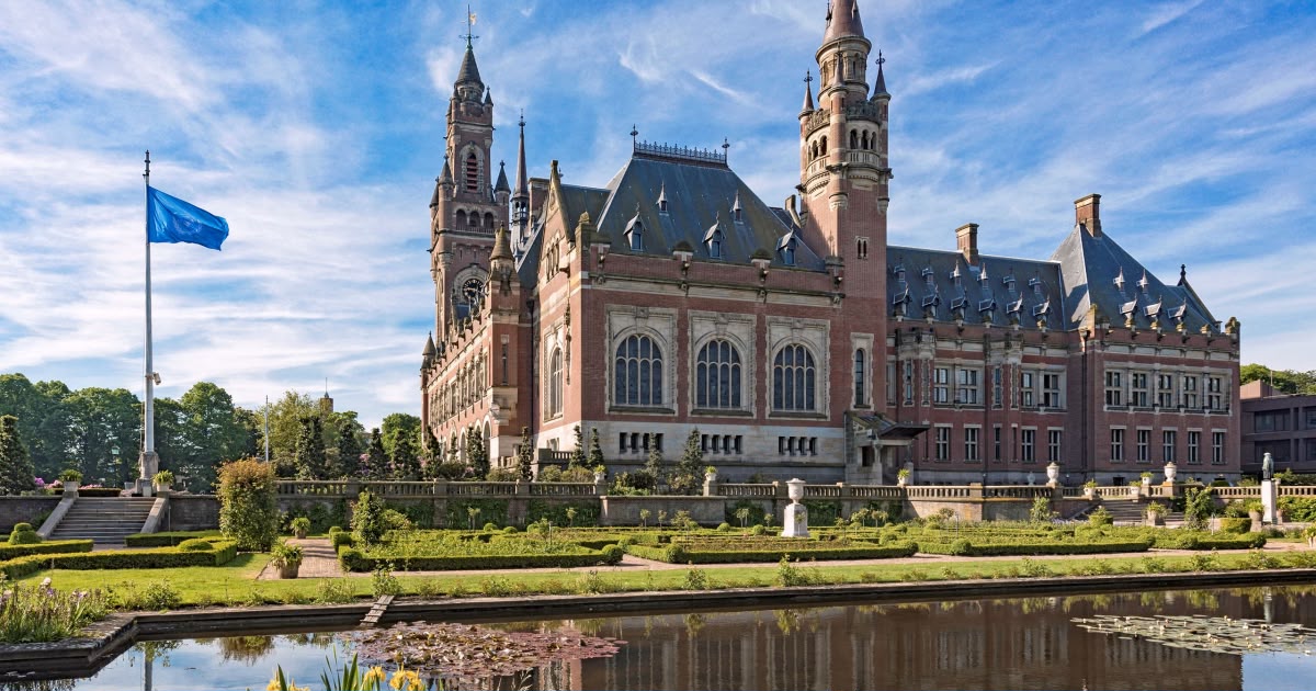 The Peace Palace and formal gardens beneath a blue sky in The Hague