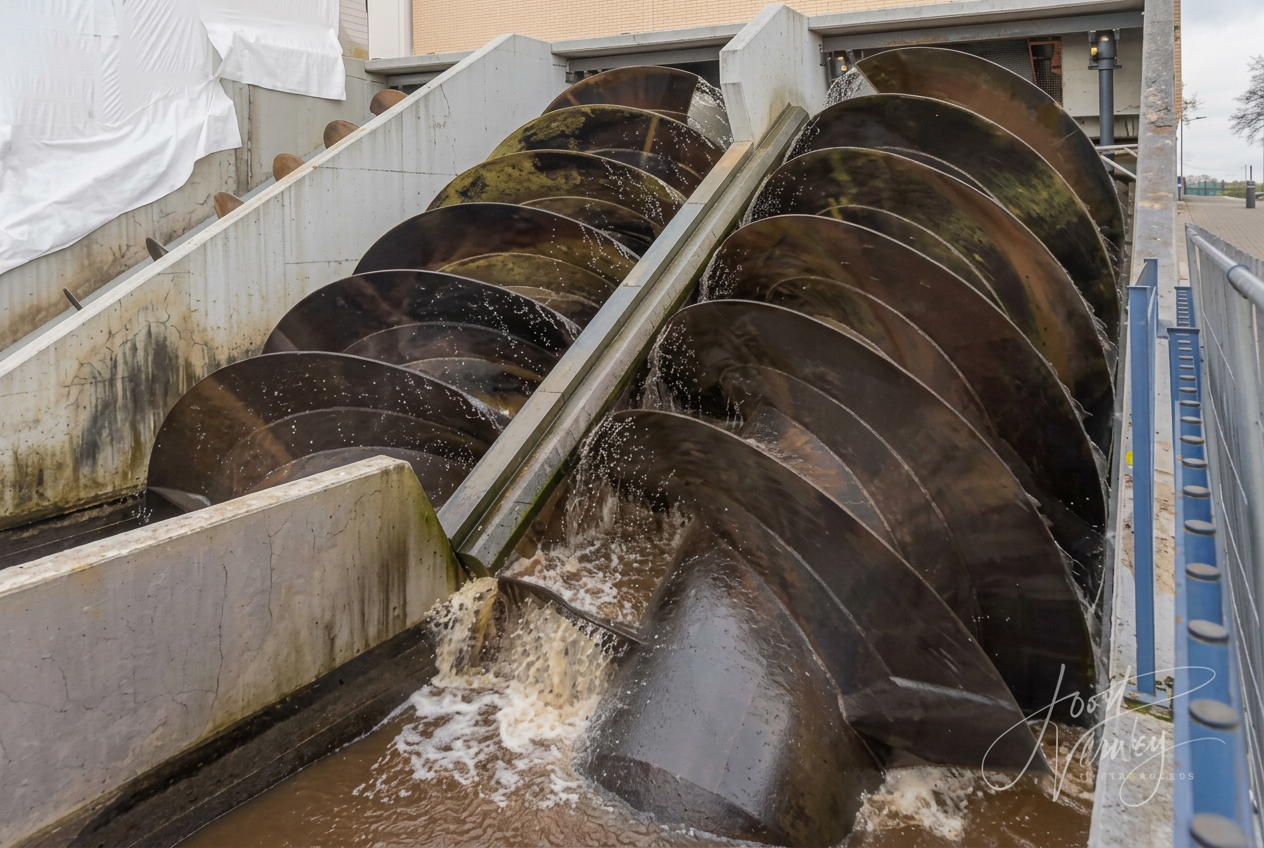Large Archimedes screw pumps lifting water at a Dutch pumping station